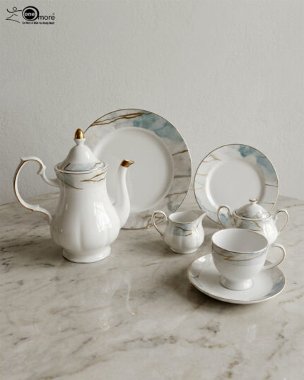 A luxurious 24-piece porcelain tea set featuring white ceramic with blue marble patterns and gold trim, displayed on a marble surface.