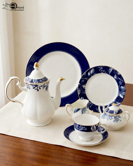 A 24-piece luxury porcelain tea set featuring a classic blue and white floral pattern with gold trim, including a teapot, cups, saucers, and plates, arranged on a beige table runner.