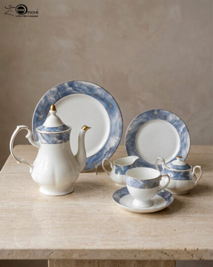 A 24-piece luxury porcelain tea set featuring a white base with elegant blue marble-patterned rims and gold accents, displayed on a textured stone surface including a teapot, cups, saucers, plates, sugar pot, and creamer.