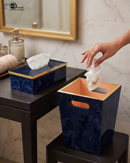A luxury blue marble resin tissue box cover and matching wastebasket with elegant gold trim on dark wooden tables in a bathroom setting.