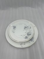 A set of 18 super bone china plates with blue floral patterns and gold rims, arranged in six place settings on a dark wooden dining table.