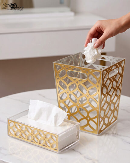 Clear acrylic dustbin and matching tissue box holder with a gold geometric lattice pattern on a white marble tabletop.