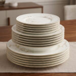 A stacked 18-piece super bone china plate set from Onemore Crockery featuring floral patterns and gold rims, displayed on a wooden table.