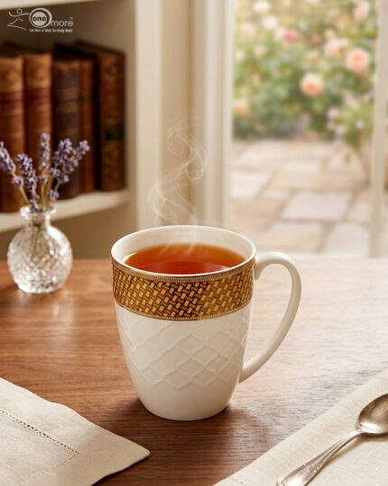 A set of elegant white bone china mugs with an embossed diamond pattern and a golden basket-weave rim, filled with steaming hot tea on a wooden table.