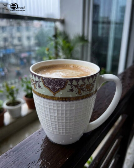 Enjoy the perfect blend of elegance and comfort with this premium bone china mug set. Featuring an intricate, vintage-inspired filigree border in deep purple and gold tones, these mugs bring a touch of royalty to your daily tea or coffee rituals. The lower half of the mug boasts a sophisticated textured grid pattern, providing a modern tactile feel and a secure grip. Crafted for those who appreciate fine craftsmanship, this set is ideal for cozy rainy mornings on the balcony or hosting guests with style. Key Features Premium Bone China: Lightweight yet durable with a smooth, translucent finish. Intricate Artistry: Beautifully detailed ethnic motifs and gold accents for a luxury aesthetic. Ergonomic Design: Large, comfortable handle and a textured body for an enhanced grip. Versatile Use: Perfect for hot tea, coffee, lattes, or hot chocolate. Capacity: Standard size, ideal for a generous serving of your favorite beverage