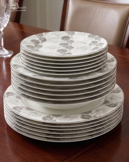 A complete Super Bone China dinner set from 6.jpg, featuring a white base with intricate grey floral borders. The set includes plates, bowls, a teapot, a tureen, and teacups displayed on a wooden surface.