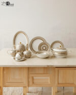 A luxury Super Bone China dinnerware set featuring a white porcelain base with intricate gold vertical ribbing and circular patterns, displayed on a marble countertop in 3.jpg