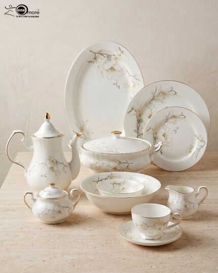 An elegant white super bone china dinner set featuring delicate beige floral patterns and gold rims, arranged on a textured beige surface. The set includes plates, bowls, a teapot, a covered casserole dish, a cream pitcher, a sugar bowl, and a teacup with a saucer.