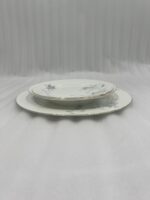 A set of 18 super bone china plates with blue floral patterns and gold rims, arranged in six place settings on a dark wooden dining table.