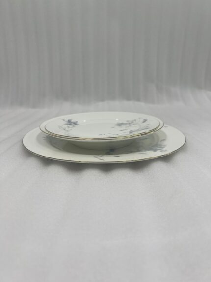 A set of 18 super bone china plates with blue floral patterns and gold rims, arranged in six place settings on a dark wooden dining table.