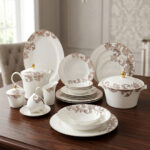 A luxury 61-piece Super Bone China dinner set by Onemore Crockery, elegantly arranged for an 8-person serving on a dark wooden dining table with a floral pattern and gold accents