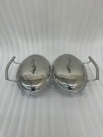 Two-dish Paramount Series stainless steel food warmer with glass bowls and chrome lids, featuring two buffet burners underneath, displayed on a wooden dining table.