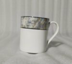 A 6-piece set of white bone china mugs as shown in 3.jpg, featuring a grey marble pattern near the rim and gold trim, displayed on a wooden desk next to books and gold spoons.