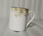 A 6-piece set of white bone china mugs as shown in 3.jpg, featuring a grey marble pattern near the rim and gold trim, displayed on a wooden desk next to books and gold spoons.