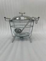 Paramount Series 4-liter glass food warmer with a stainless steel stand, lid, and ladle, featuring a buffet burner holder on a wooden dining table.