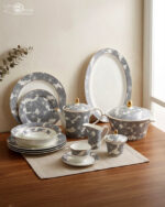 61-piece luxury Super Bone China dinnerware set with grey floral patterns and gold accents, including plates, tea pot, and serving bowls on a wooden table