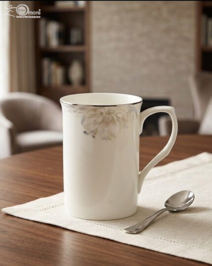 A high-angle shot labeled 3.jpg showing two elegant white bone china mugs with floral patterns and silver rims on a marble countertop next to silver spoons