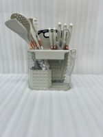 A comprehensive 16-piece kitchen tool set featuring cream-colored silicone utensils with marble-patterned handles, rose gold accents, a matching knife set, kitchen shears, a peeler, and a cutting board, all stored in a clear geometric organizer.