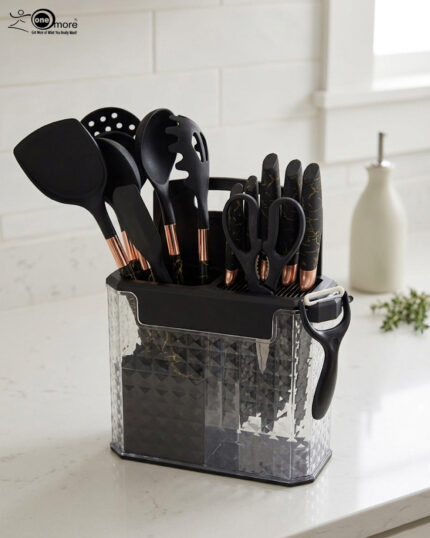 A comprehensive 17-piece kitchen tool set featuring black and rose gold silicone utensils, a matching knife set with marble-patterned handles, a vegetable peeler, kitchen shears, and a black cutting board, all stored in a clear geometric textured organizer.
