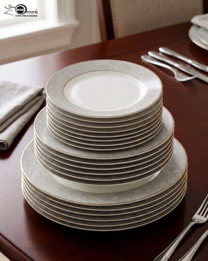 A stacked 18-piece elegant super bone china plate set on a dark wooden dining table. The set includes quarter plates on top, deep plates in the middle, and large rice plates at the bottom, all featuring a light grey floral pattern border and gold trim