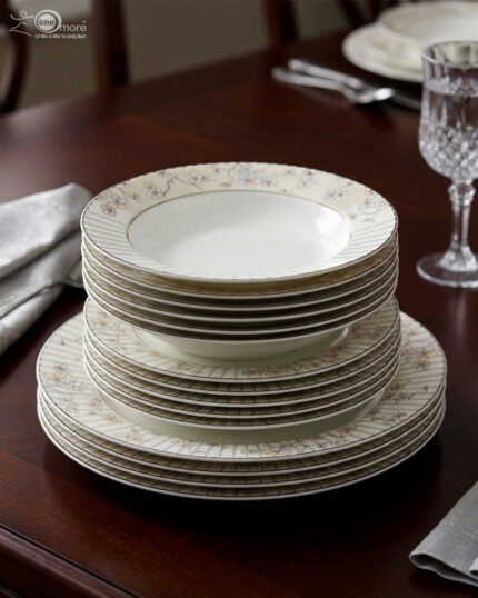 A stack of 18-piece premium bone china dinnerware featuring floral patterns and pinstripe borders on a dark wooden table
