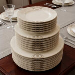 A stacked 18-piece premium super bone china dinner plate set showing 6 quarter plates, 6 deep soup plates, and 6 large rice plates with elegant golden-beige damask borders on a luxury wooden dining table setup