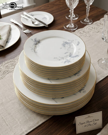 A set of 18 super bone china plates with blue floral patterns and gold rims, arranged in six place settings on a dark wooden dining table.