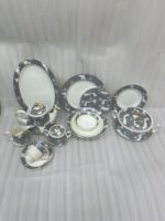 A luxurious super bone china dinner set from Onemore Crockery featuring a grey floral design and gold accents, including plates, bowls, a teapot, and serving dishes arranged on a wooden surface as seen in 7.jpg.