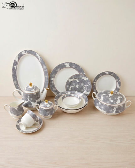 A luxurious super bone china dinner set from Onemore Crockery featuring a grey floral design and gold accents, including plates, bowls, a teapot, and serving dishes arranged on a wooden surface as seen in 7.jpg.