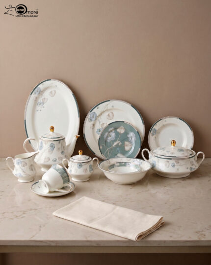 A luxury super bone china dinner set with delicate blue floral patterns and gold accents, including plates, bowls, and a tea service set on a marble surface.