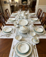 A luxury super bone china dinner set with delicate blue floral patterns and gold accents, including plates, bowls, and a tea service set on a marble surface.