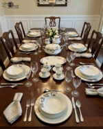 A luxury super bone china dinner set featuring a white base and intricate brown acanthus leaf patterns, including plates, bowls, a teapot, and serving dishes on a wooden table.