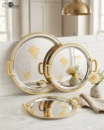 A luxury 3-piece round stainless steel serving tray set with gold textured handles and etched gold floral designs, arranged on a marble kitchen countertop as shown in 1.jpg.