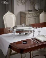 One More 3-liter premium stainless steel rectangular chafing dish with ornate legs and dual buffet burners on a luxury dining table setup.