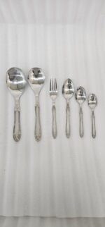 High-quality stainless steel cutlery set featuring table spoons, tea spoons, forks, and serving utensils arranged on a dark wooden background, as displayed in 7.jpg.