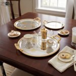 A luxury 3-piece round stainless steel serving tray set with gold textured handles and etched gold floral designs, arranged on a marble kitchen countertop as shown in 1.jpg.