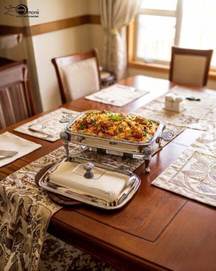 One More 3-liter premium stainless steel rectangular chafing dish with ornate legs and dual buffet burners on a luxury dining table setup.