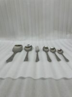 A high-quality 53-piece stainless steel cutlery set featuring elegant patterned handles, displayed on a grey fabric surface as shown in 9.jpg.