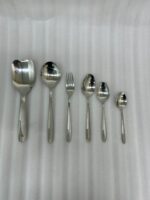 A high-angle view of a complete 53-piece stainless steel cutlery set arranged neatly on a wooden table, as displayed in 7.jpg