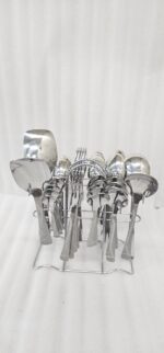 Overhead view of a 37-piece stainless steel cutlery set, including table spoons, forks, knives, and serving utensils arranged on a wooden table, as depicted in 7.jpg.
