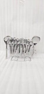 High-quality stainless steel cutlery set featuring table spoons, tea spoons, forks, and serving utensils arranged on a dark wooden background, as displayed in 7.jpg.