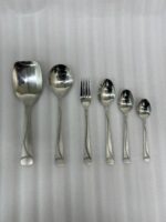 A high-quality 53-piece stainless steel cutlery set arranged elegantly on a dark wood background featuring various spoons, forks, and knives as displayed in 6.jpg.