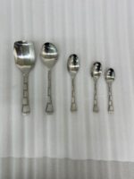 An elegant assortment of stainless steel flatware, including various spoons, forks, and knives arranged on a wooden table as featured in 6.jpg, representing a complete 53-piece dining set.