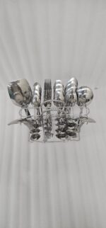 Overhead view of a 37-piece stainless steel cutlery set, including table spoons, forks, knives, and serving utensils arranged on a wooden table, as depicted in 7.jpg.