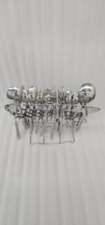 High-quality stainless steel cutlery set featuring table spoons, tea spoons, forks, and serving utensils arranged on a dark wooden background, as displayed in 7.jpg.