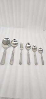 A complete 37-piece stainless steel cutlery set, including various spoons, forks, and knives with decorative handles, displayed on a linen tablecloth as shown in 7.jpg.