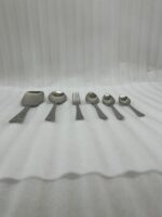 A high-quality 53-piece stainless steel cutlery set arranged elegantly on a dark wood background featuring various spoons, forks, and knives as displayed in 6.jpg.