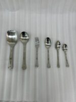 A complete 53-piece stainless steel dining cutlery set featuring spoons, forks, knives, and a serving stand displayed elegantly on a wooden background, as featured in 8.jpg.