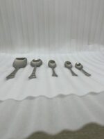 An elegant assortment of stainless steel flatware, including various spoons, forks, and knives arranged on a wooden table as featured in 6.jpg, representing a complete 53-piece dining set.