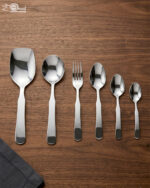 A complete 53-piece stainless steel cutlery set featuring various spoons, forks, and knives displayed on a wooden surface in 6.jpg, showcasing the polished finish and modern design.